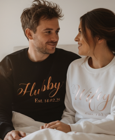 Lifestyle image of a husband and wife in matching 'Hubby Wifey' sweatshirts after their wedding. Perfect for personalised couple hoodies, wedding gifts, anniversary presents, and newlywed apparel