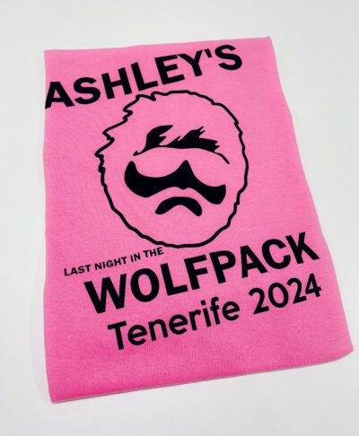 Bright pink personalised stag do t-shirt with bold black “Last Night in the Wolfpack” design, custom groom’s name, location, and date.