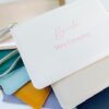 Personalised faux leather clutch bags in multiple colours with custom name text – ideal gifts for brides, bridesmaids, and the bridal party.