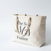 Personalised natural canvas tote bag featuring 'The New Mrs Foster' printed in black script, with thick rope handles, ideal for honeymoon or beach use