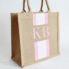 Personalised natural jute tote bags with pink stripe detail and pink initial monogram, perfect as bridesmaid gifts, wedding welcome bags, or hen party favours.