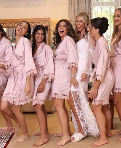 Bridesmaids wearing personalised satin lace robe in nude pink